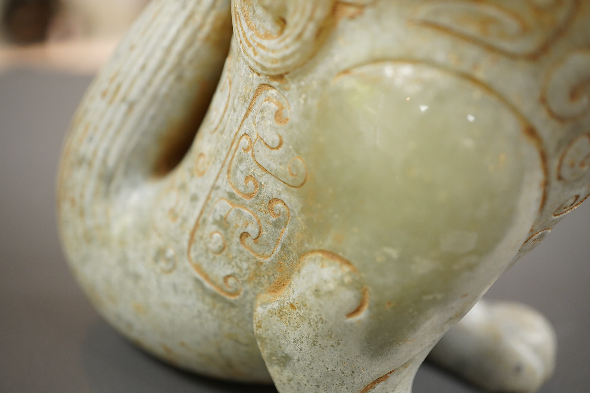 A large Chinese archaistic pale celadon and calcified jade rhyton